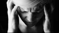 Black and white image of woman with her head in her hands