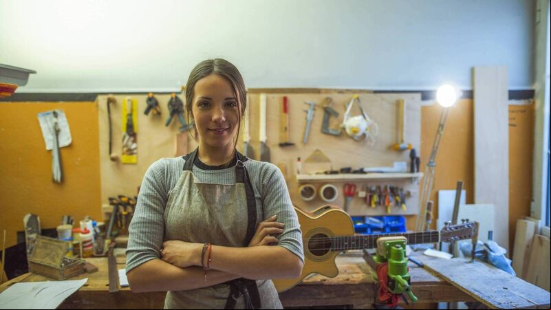 iStock-955486898.jpg woman luthier small business owner portrait, in her musical instrument workshop