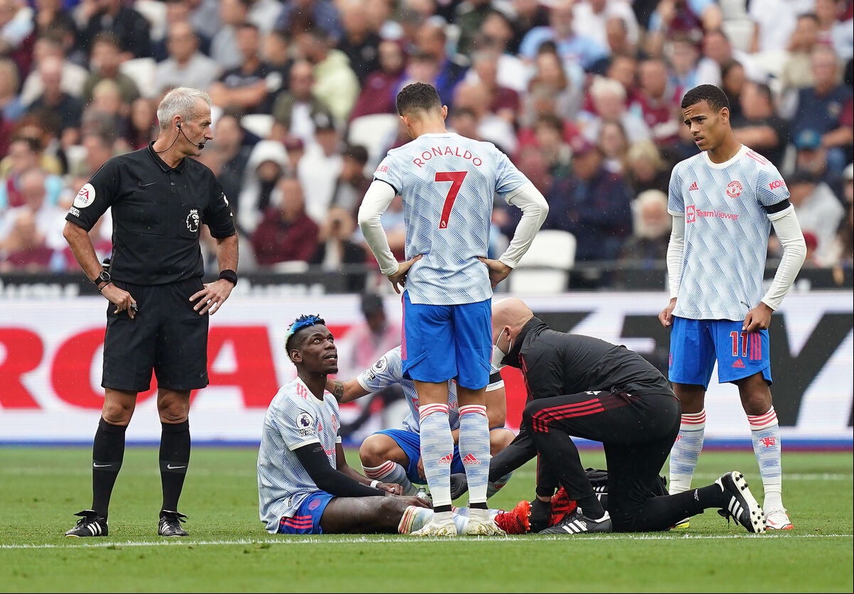 Referee Martin Atkinson (left), Manchester United's Cristiano Ronaldo and Mason Greenwood look on as Paul Pogba receive treatment for an injury during the Premier League match against West Ham at the London Stadium, London. Picture: Mike Egerton/PA Wire. Referee Martin Atkinson (left), Manchester United's Cristiano Ronaldo and Mason Greenwood look on as Paul Pogba receive treatment for an injury during the Premier League match against West Ham at the London Stadium, London. Picture: Mike Egerton/PA Wire.