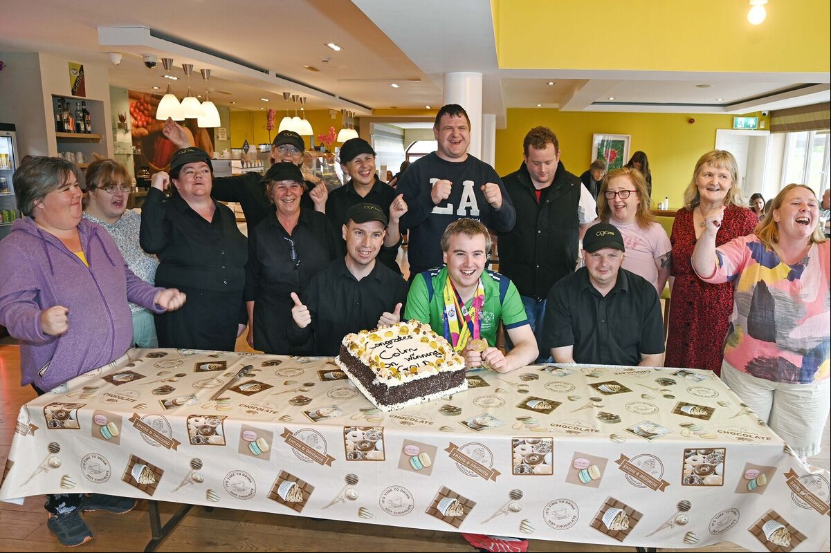 Colm Monahan, a member of the staff at Chapel Gate Café, Ballincollig, run by the Brothers of Charity, during a celebration in his honour in the café on his return with a men's singles gold medal for bton at the Special Olympics World Games pictured with the café staff and manager Anne Cahill. Picture: Denis Minihane. Colm Monahan, a member of the staff at Chapel Gate Café, Ballincollig, run by the Brothers of Charity, during a celebration in his honour in the café on his return with a men's singles gold medal for bton at the Special Olympics World Games pictured with the café staff and manager Anne Cahill. Picture: Denis Minihane.