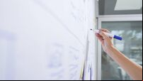Female entrepreneur drawing on whiteboard