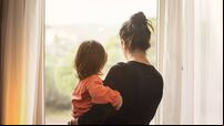 Mother and son looking out of window