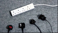 Unused extension lead and four disconnected plugs lying on carpet
