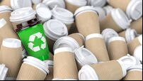 Recycling  sign on one of the heap of many empty paper coffee cups.