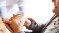 Unrecognizable health visitor and a senior woman during home visit.
