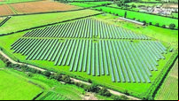 Aerial view of solar s on green field at suburb in sunny day