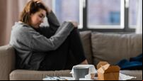 stressed woman sitting on sofa at home