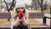 Depression and loneliness. Woman in trouble sitting on bench in autumn park crying covering face with hands. Mental health