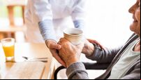 Unrecognizable health visitor and a senior woman during home visit.