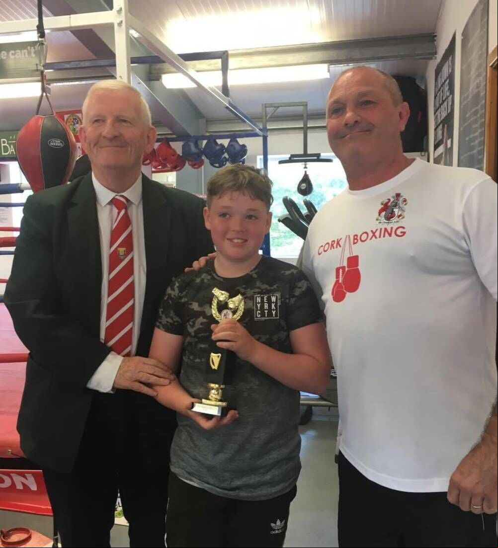 Cork Boxing County Board president Michael O'Brien with De Courey boxer Leon Healy and head coach Will Rossall. Cork Boxing County Board president Michael O'Brien with De Courey boxer Leon Healy and head coach Will Rossall.
