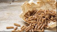 wholemeal pasta fusilli from organic whole grain spelt on paper