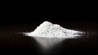 A small pile of white powder on a dark surface