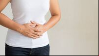 Young woman having painful stomachache. Chronic gastritis. Abdomen bloating concept.